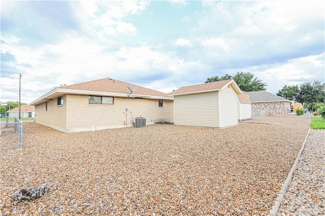 rear view of property with an outbuilding and central AC