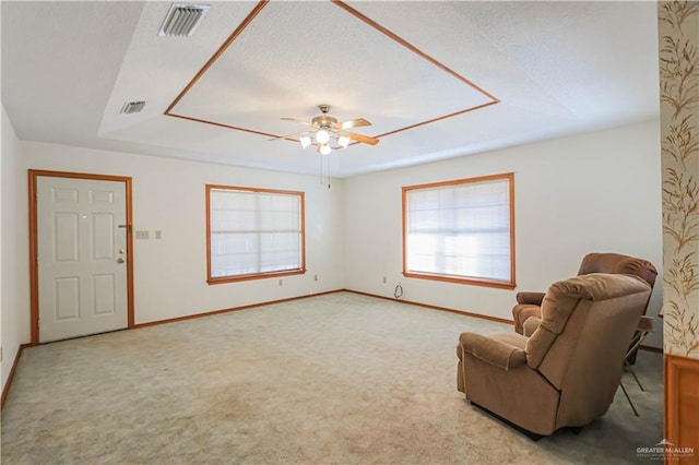 unfurnished room featuring a textured ceiling, ceiling fan, and light carpet