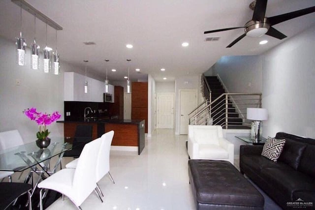 living room with ceiling fan and sink