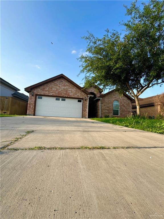 ranch-style house featuring brick siding and driveway