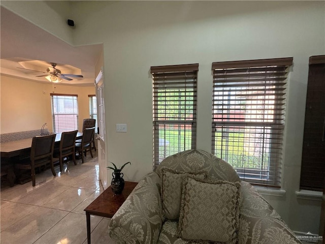 living area featuring light tile patterned floors and a ceiling fan