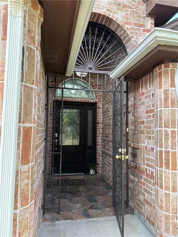 view of exterior entry with brick siding