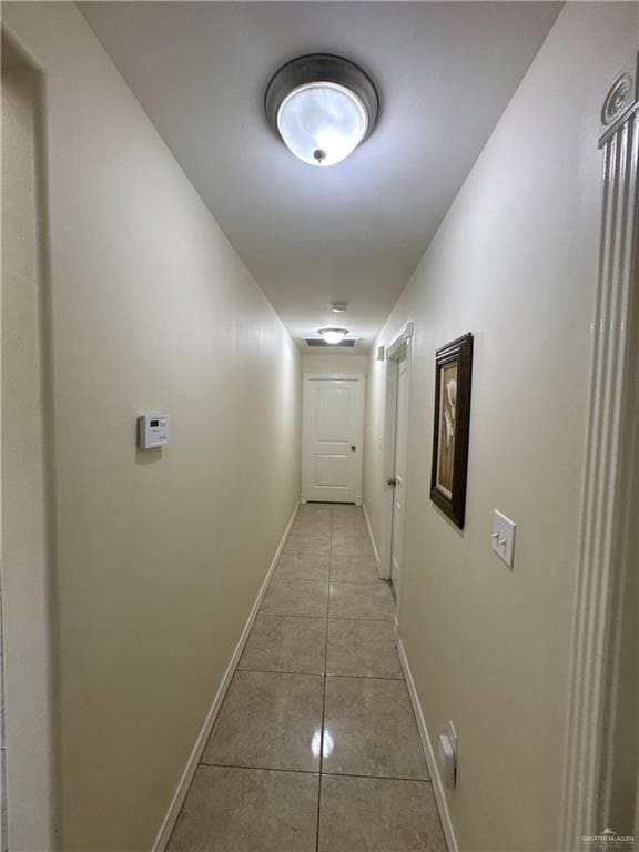 hall featuring baseboards and tile patterned flooring