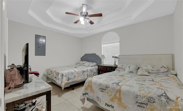 bedroom with a ceiling fan, electric panel, and a tray ceiling