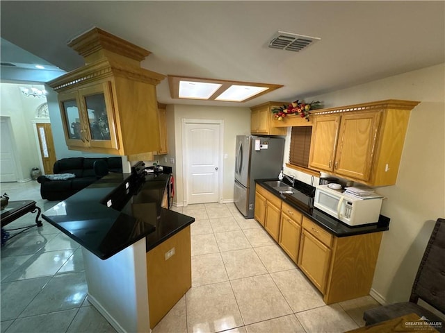kitchen featuring glass insert cabinets, light tile patterned flooring, visible vents, and a peninsula