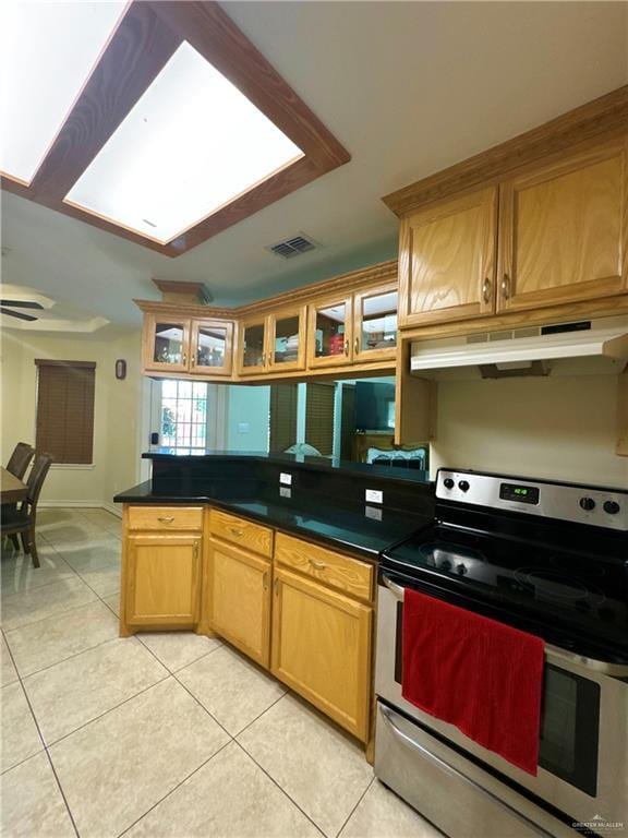 kitchen featuring light tile patterned floors, visible vents, stainless steel electric stove, and under cabinet range hood