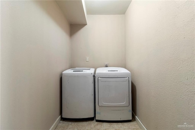 laundry room featuring washing machine and clothes dryer and light tile patterned floors