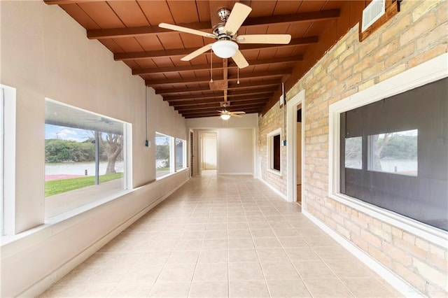 hallway with beamed ceiling, brick wall, light tile patterned floors, and wooden ceiling