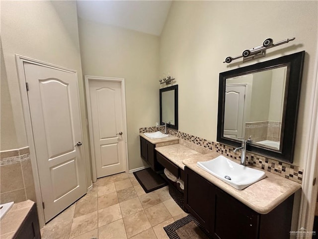 bathroom with lofted ceiling, vanity, and decorative backsplash