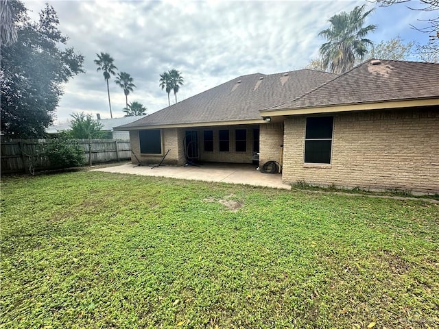 rear view of property featuring a patio area and a lawn