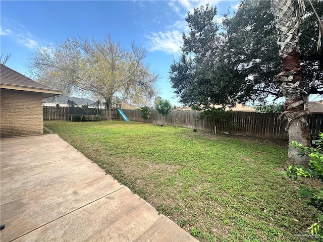 view of yard with a trampoline, a patio area, and a playground