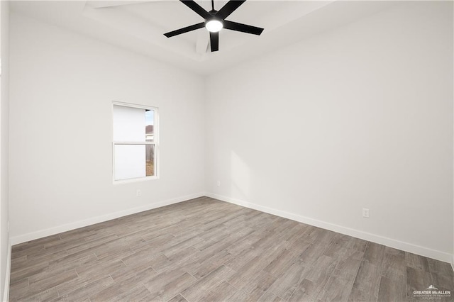 empty room with ceiling fan and light hardwood / wood-style flooring