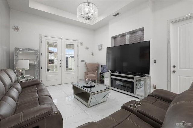 3108 E Bella Vista Ave, Alton, TX 78573 - living area featuring french doors, a chandelier, marble finish flooring, and a tray ceiling