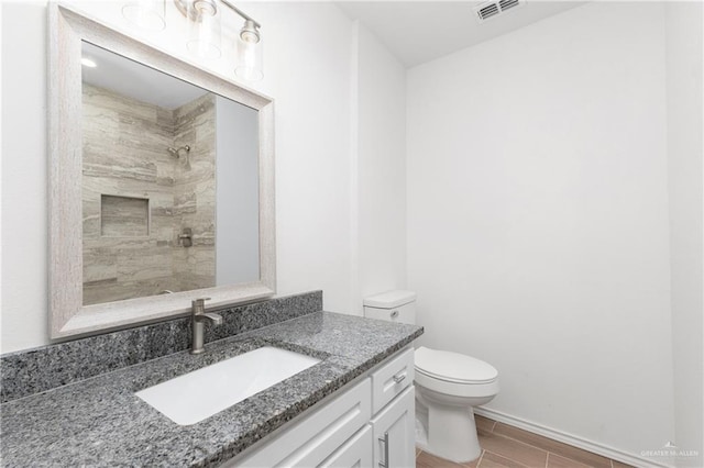 2013 Mynah Ave, Mcallen, TX 78504 - bathroom with tiled shower, toilet, visible vents, vanity, and wood finish floors