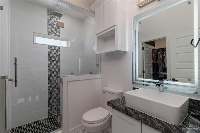 full bathroom with toilet, a stall shower, and vanity