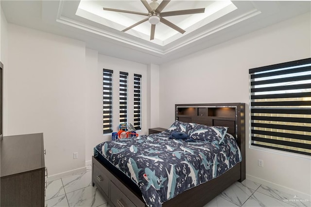 bedroom with marble finish floor, baseboards, a tray ceiling, and a ceiling fan