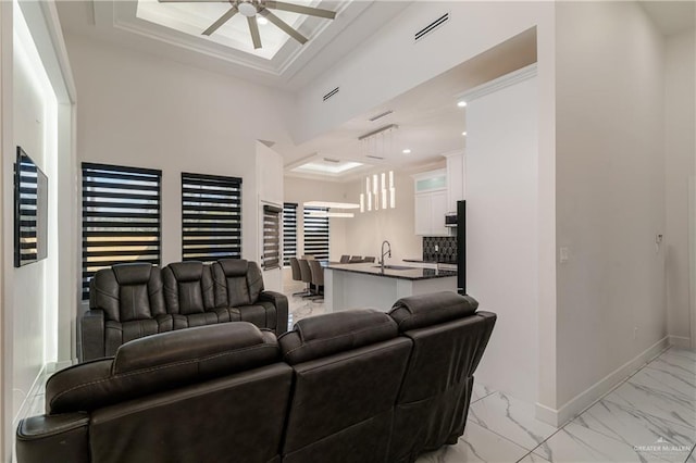 living room featuring a ceiling fan, visible vents, baseboards, marble finish floor, and a raised ceiling