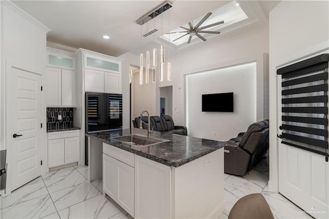 kitchen with marble finish floor, a ceiling fan, open floor plan, and a sink