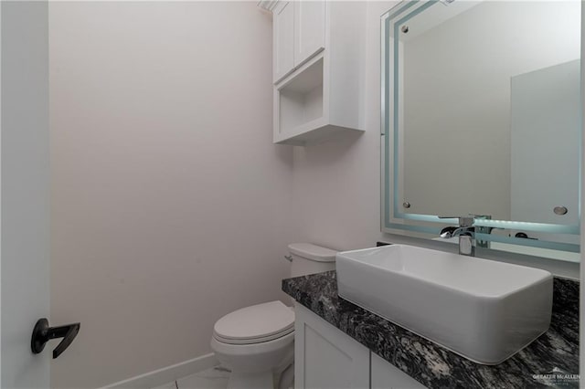 bathroom with marble finish floor, vanity, toilet, and baseboards