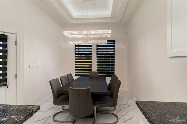 dining space with marble finish floor, a tray ceiling, and baseboards