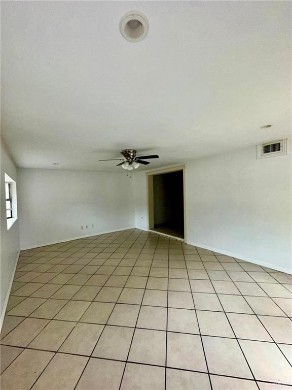 unfurnished room with ceiling fan and light tile patterned flooring