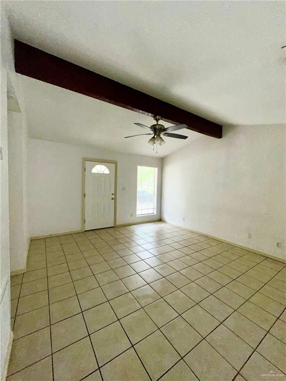 interior space featuring beamed ceiling, ceiling fan, and light tile patterned floors