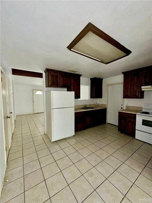 kitchen featuring light tile patterned floors and white appliances