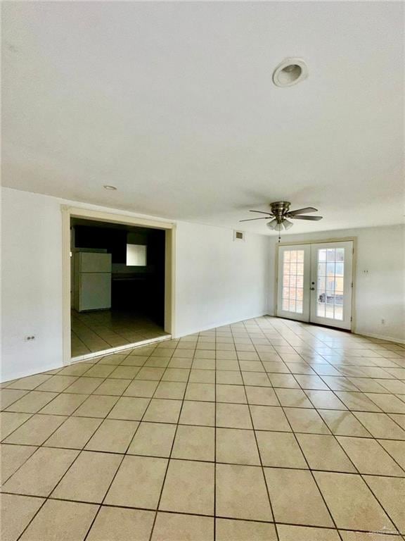 tiled spare room with ceiling fan and french doors