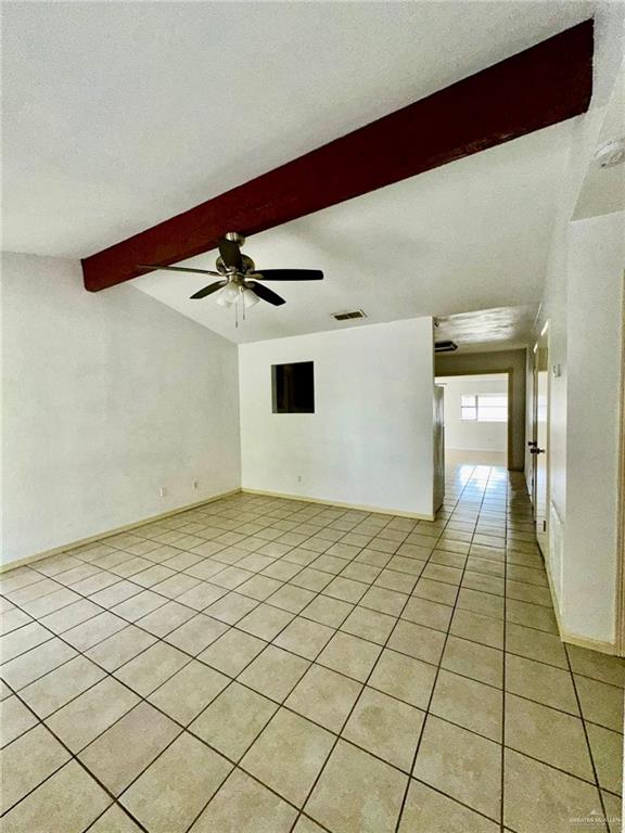 tiled spare room with beamed ceiling and ceiling fan