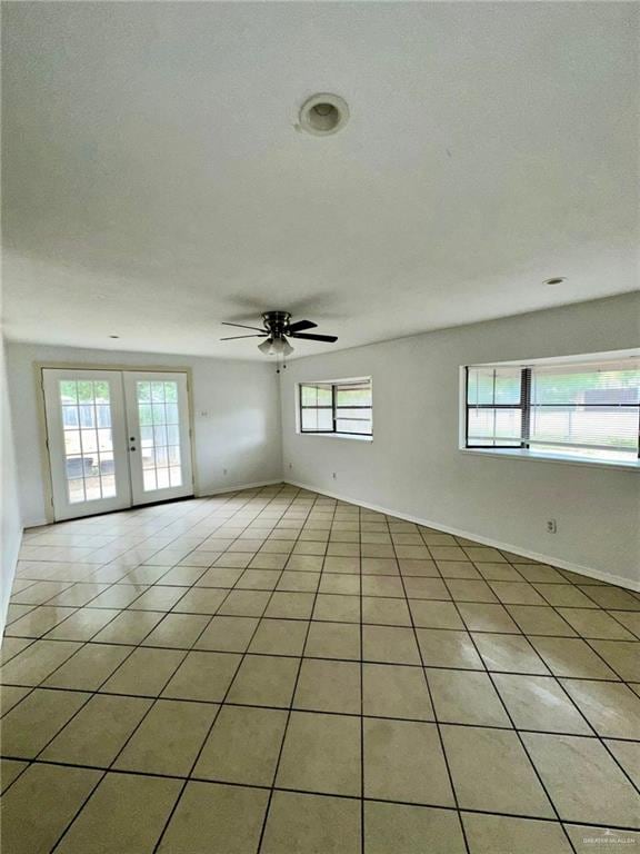 spare room with ceiling fan, french doors, and light tile patterned floors