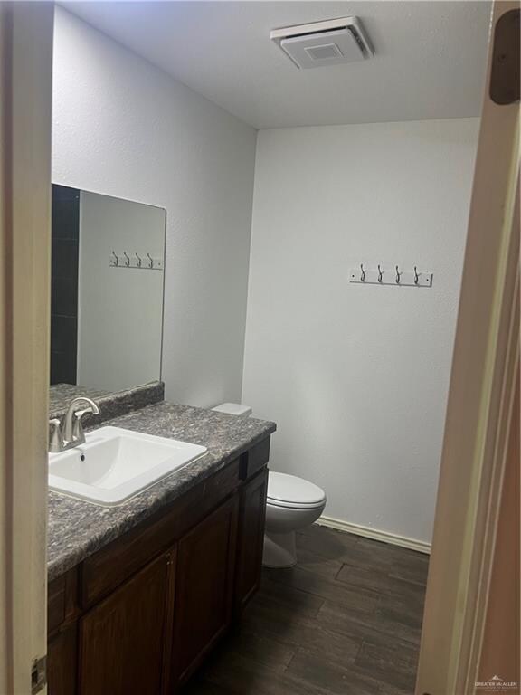 bathroom featuring hardwood / wood-style floors, vanity, and toilet