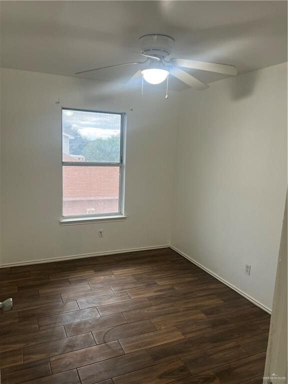 unfurnished room featuring ceiling fan and dark hardwood / wood-style flooring