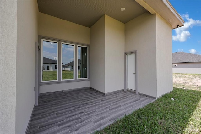 doorway to property featuring stucco siding and a yard