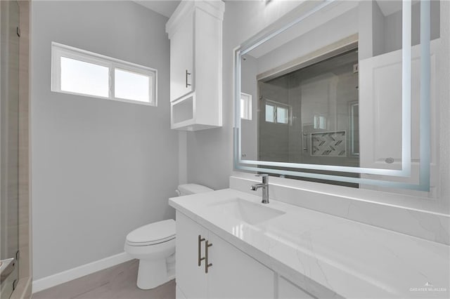 full bathroom with vanity, baseboards, toilet, and a shower stall