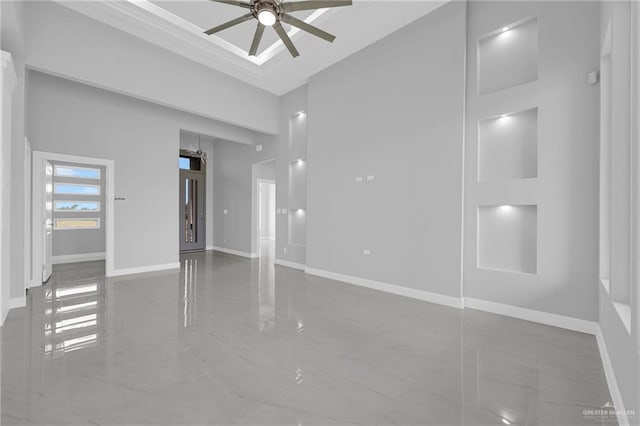 unfurnished bedroom featuring baseboards, a ceiling fan, and a towering ceiling