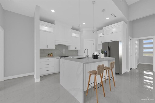 1012 Azalea St, Mission, TX 78573 - kitchen with a breakfast bar, a sink, white cabinetry, stainless steel fridge, and light countertops