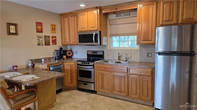 2422 Starling Cir E, Palmview, TX 78572 - kitchen with stainless steel appliances, a peninsula, a sink, backsplash, and a breakfast bar area