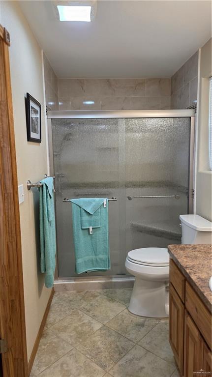 2422 Starling Cir E, Palmview, TX 78572 - full bath with vanity, a shower stall, toilet, and tile patterned floors