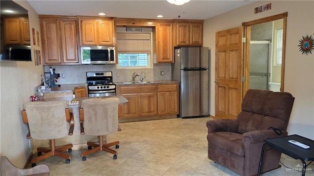 2422 Starling Cir E, Palmview, TX 78572 - kitchen with stainless steel appliances, a sink, tasteful backsplash, brown cabinetry, and recessed lighting
