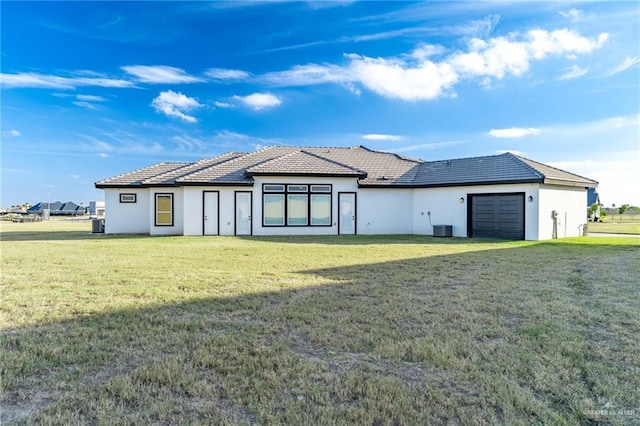 view of front of home with cooling unit, an attached garage, a front lawn, and stucco siding