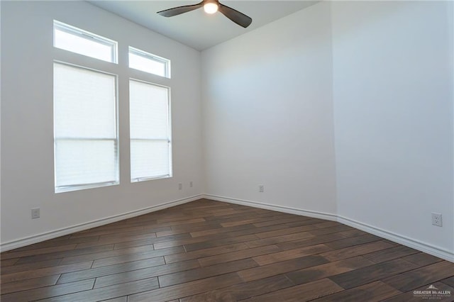 empty room featuring dark wood-type flooring, baseboards, and a ceiling fan