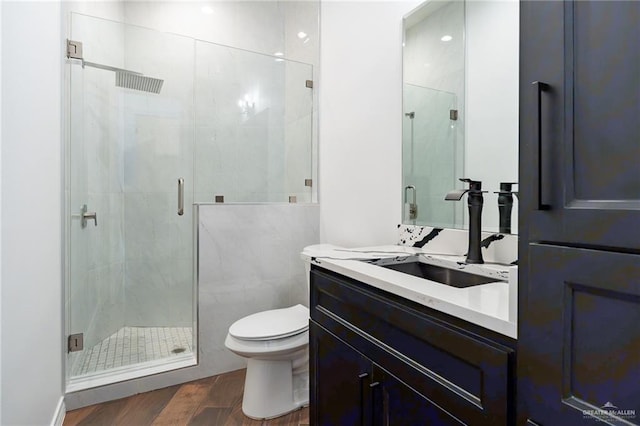 full bath featuring toilet, a stall shower, wood finished floors, and vanity