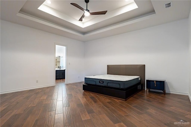 unfurnished bedroom with baseboards, visible vents, a ceiling fan, a raised ceiling, and dark wood-style flooring