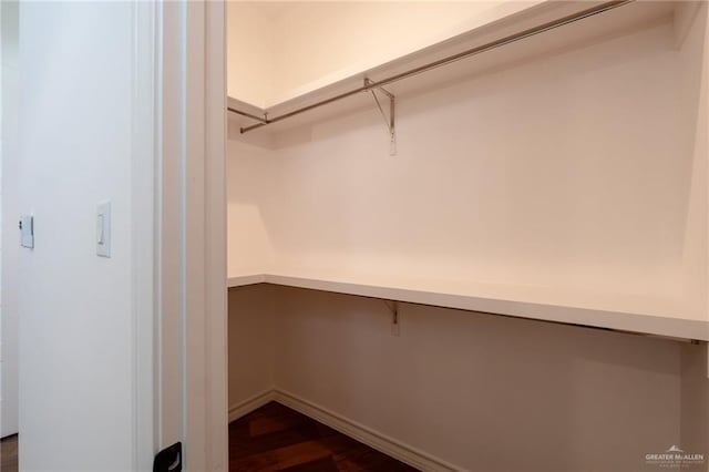 spacious closet with dark wood-style flooring