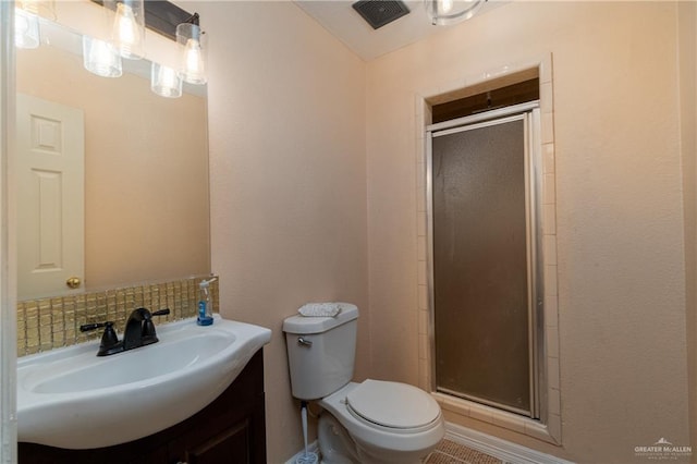 bathroom with a shower with door, vanity, decorative backsplash, and toilet