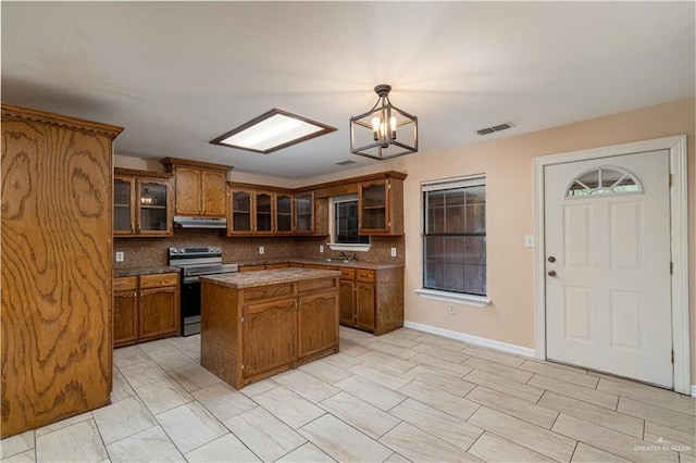 kitchen with a kitchen island, pendant lighting, decorative backsplash, and electric stove