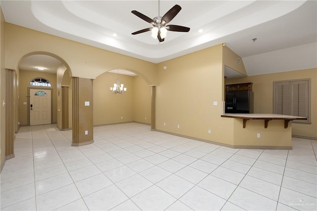 unfurnished living room with a raised ceiling, light tile patterned floors, and ceiling fan