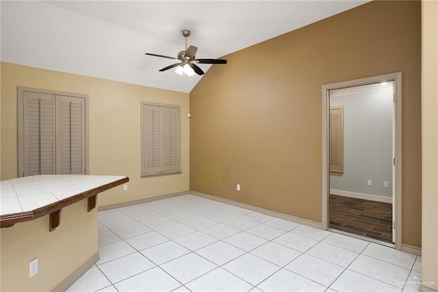 tiled spare room featuring lofted ceiling and ceiling fan