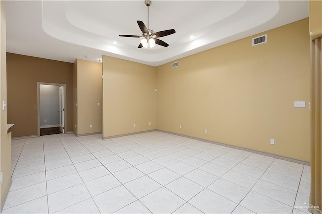 empty room with a raised ceiling and ceiling fan