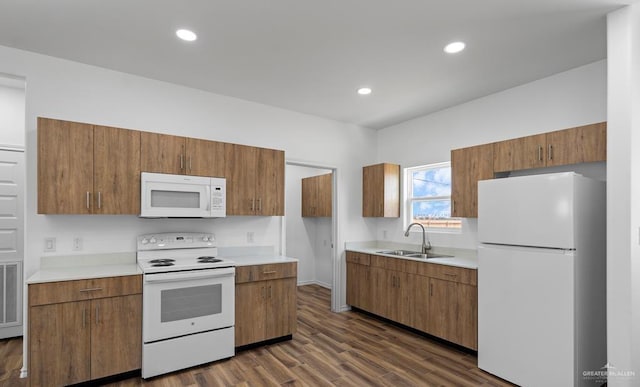 kitchen with white appliances, dark hardwood / wood-style floors, and sink